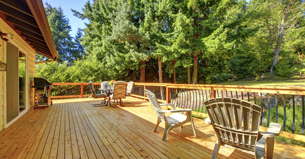 Large freshly painted new wooden deck with nice summer green back